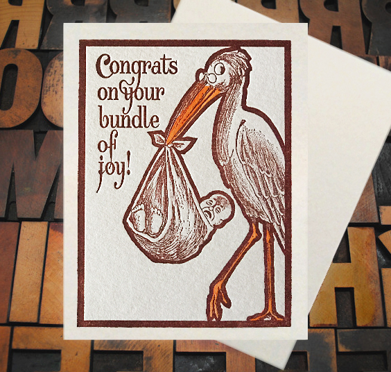 Letterpress Card with an image of a stork carrying an upset baby in a sack with the text, "Congrats on your bundle of joy!"