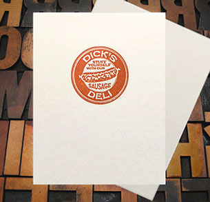 Letterpress Card with a vintage emblem containing the text, "Dicks Deli—Stuff Yourself With Our Sausage" and an image of a sausage