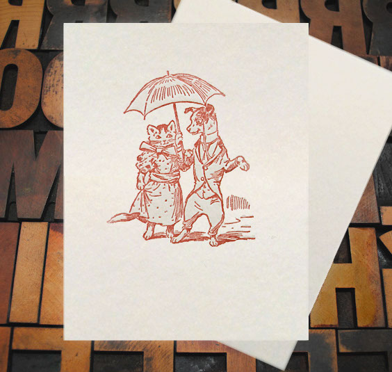Letterpress Card with an image of a dog and a cat on a date, wearing clothes and carrying an umbrella