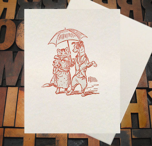 Letterpress Card with an image of a dog and cat holding an umbrella while wearing clothes