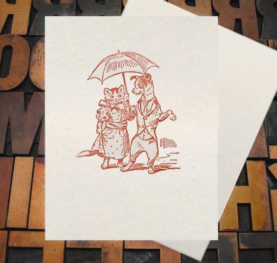 Letterpress Card with an image of a dog and cat holding an umbrella while wearing clothes
