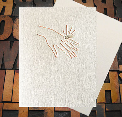 Letterpress Card with an image of a woman's hand bearing an engagement ring that features a real rhinestone