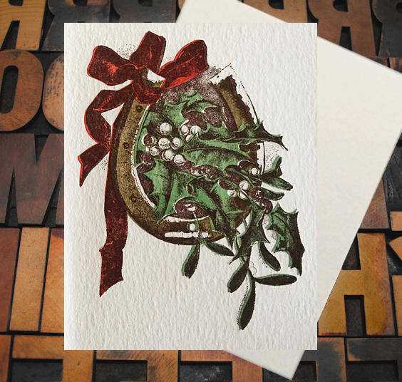 Letterpress Card with an image of a horseshoe, ribbon, holly leaves, and mistletoe