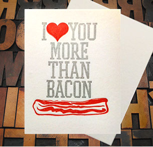 Letterpress Card with the text, "I -heart shape- you more than bacon" over an image of a strip of bacon
