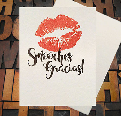 Letterpress Card with an image of lip imprints over top of the text, "Smooches Gracias!"