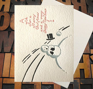Letterpress Card with the text, "A wish for a Merry Christmas and a very Happy New Year" and a snowman getting his hat knocked off by a snowball